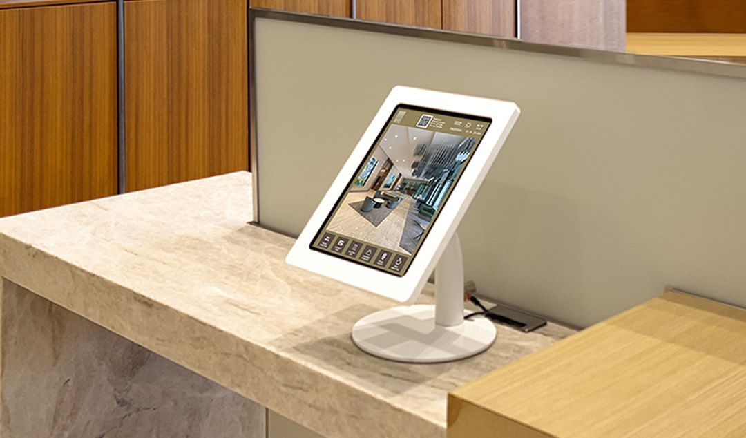 Tablet kiosk on a light brown marble reception counter