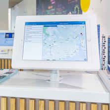 modern informational kiosk with interactive screen in open, colorful space