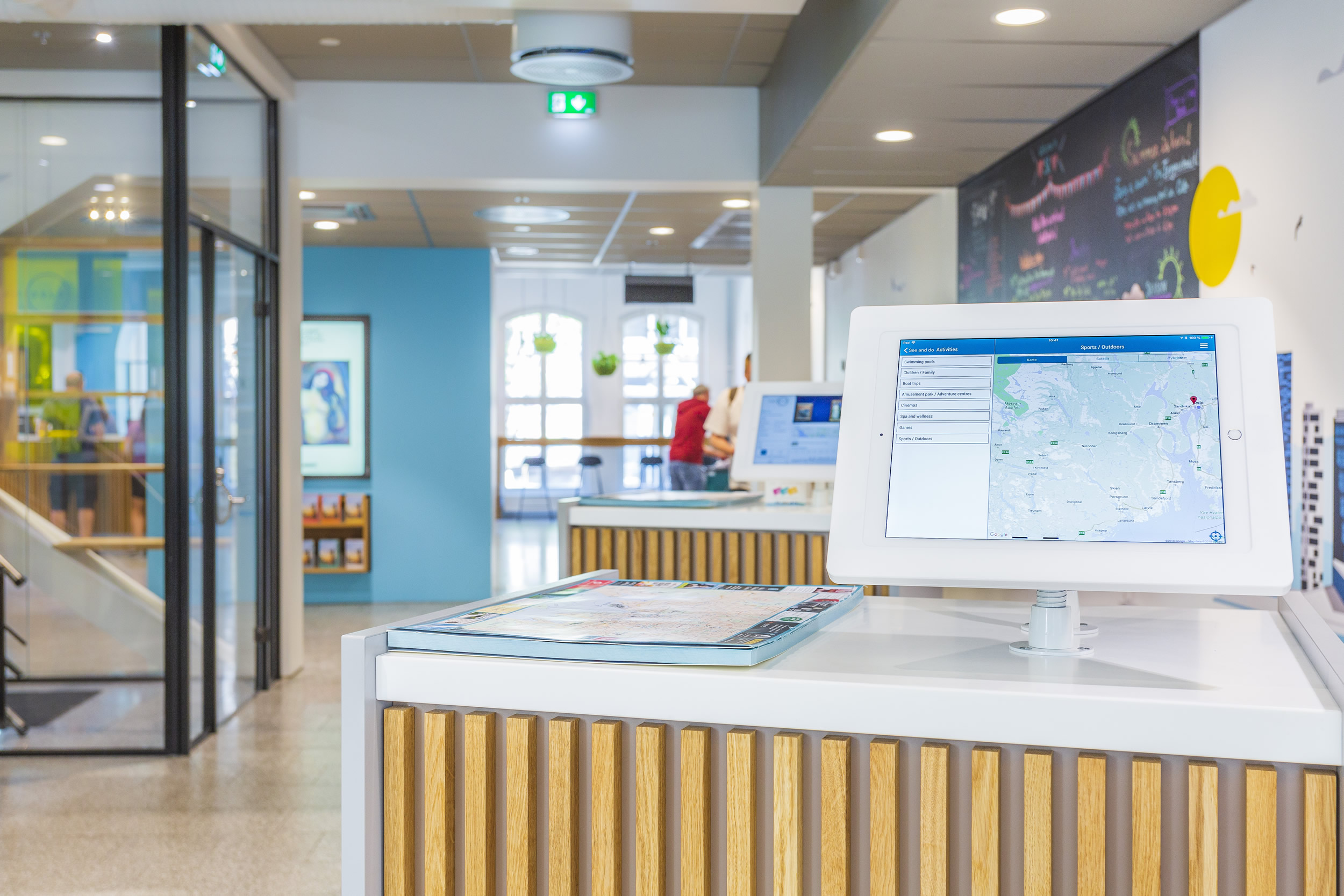 modern informational kiosk with interactive screen in open, colorful space