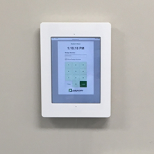 iPad tablet running a dedicated timeclock app, mounted onto a wall